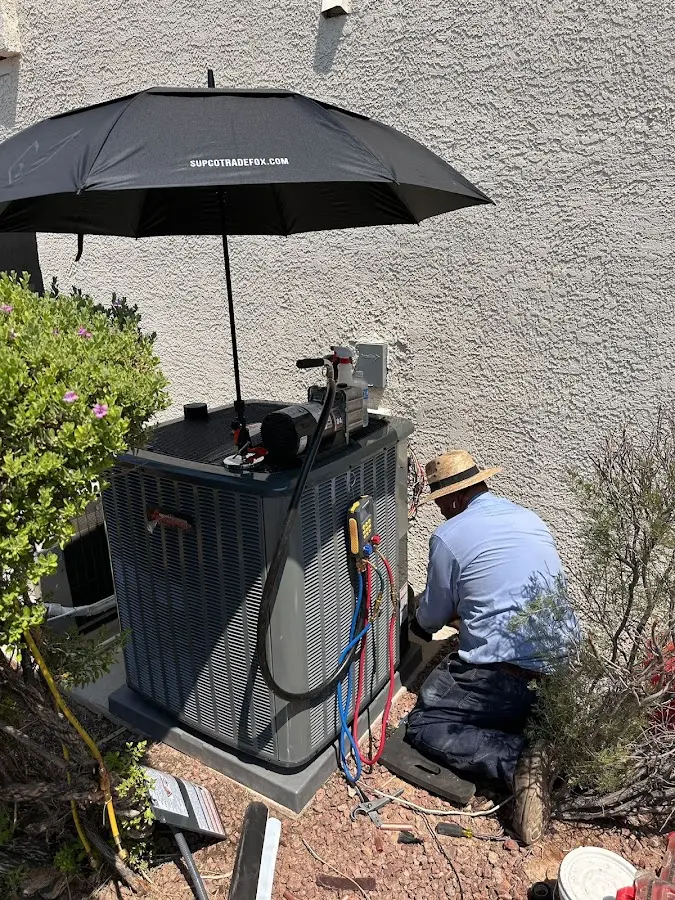 HVAC technician performing outdoor AC maintenance in Groton